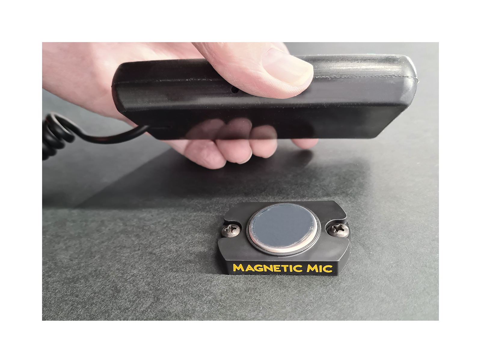 Mag Mic Mounted on Surface Action Shot Hand Approaching with Handset